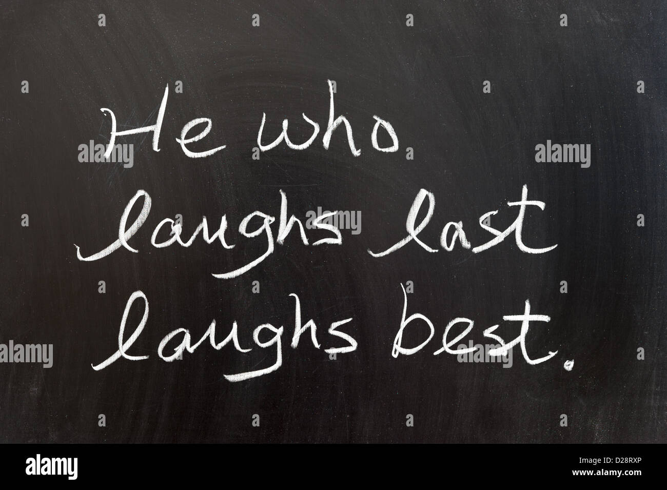 He who laughs last laughs best saying written on chalkboard Stock Photo