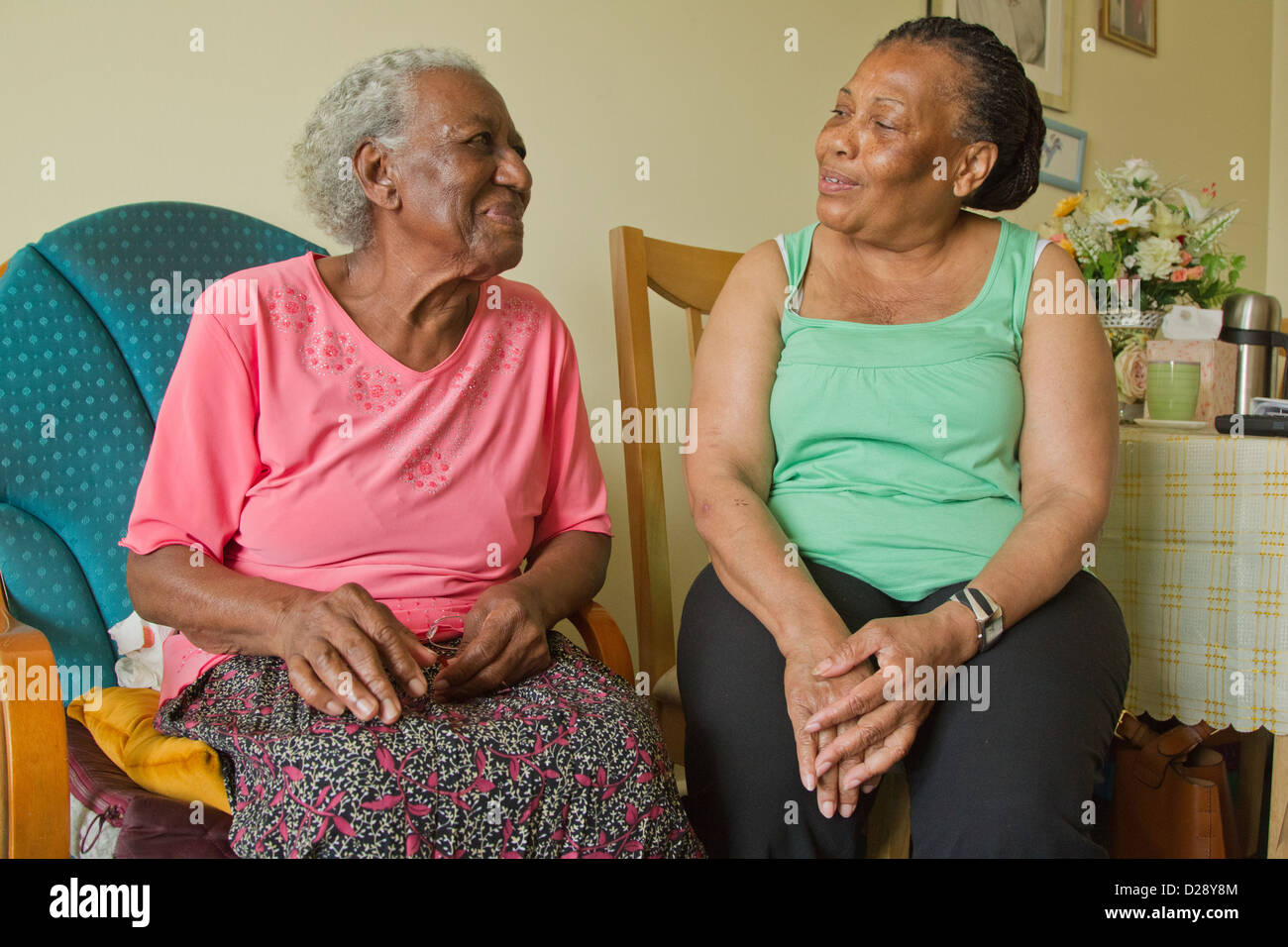 Carer and elderly visually impaired woman chatting Stock Photo