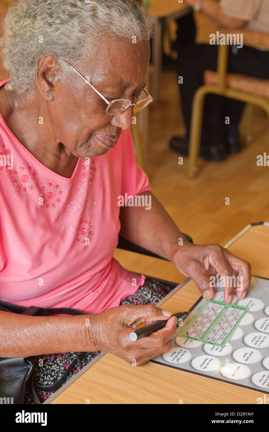 Elderly visually impaired woman playing bingo Stock Photo