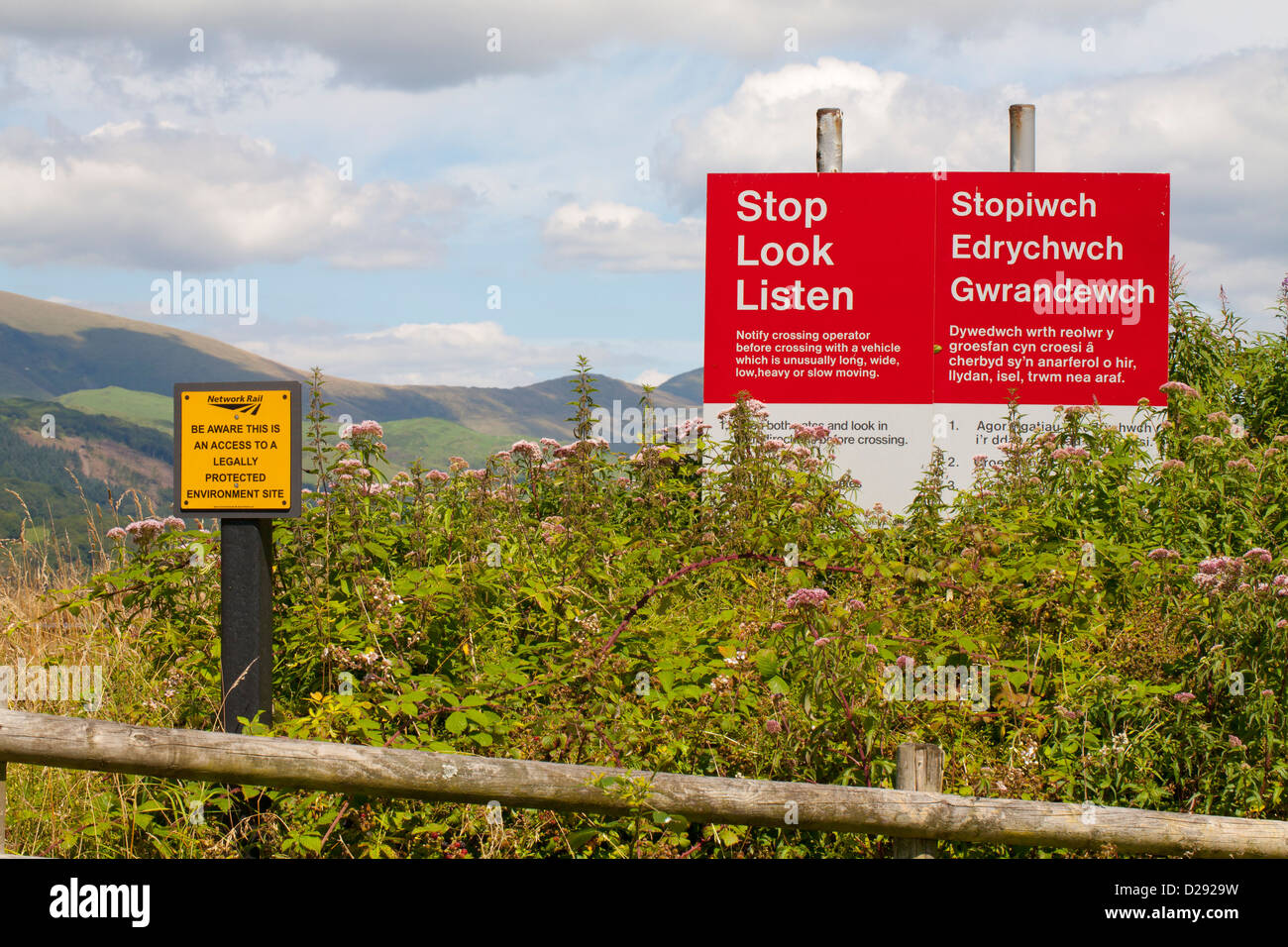 Stop, Look, Listen sign and others at a rural farm railway crossing. RSPB Ynys Hir reserve. Ceredigion, Wales. August. Stock Photo