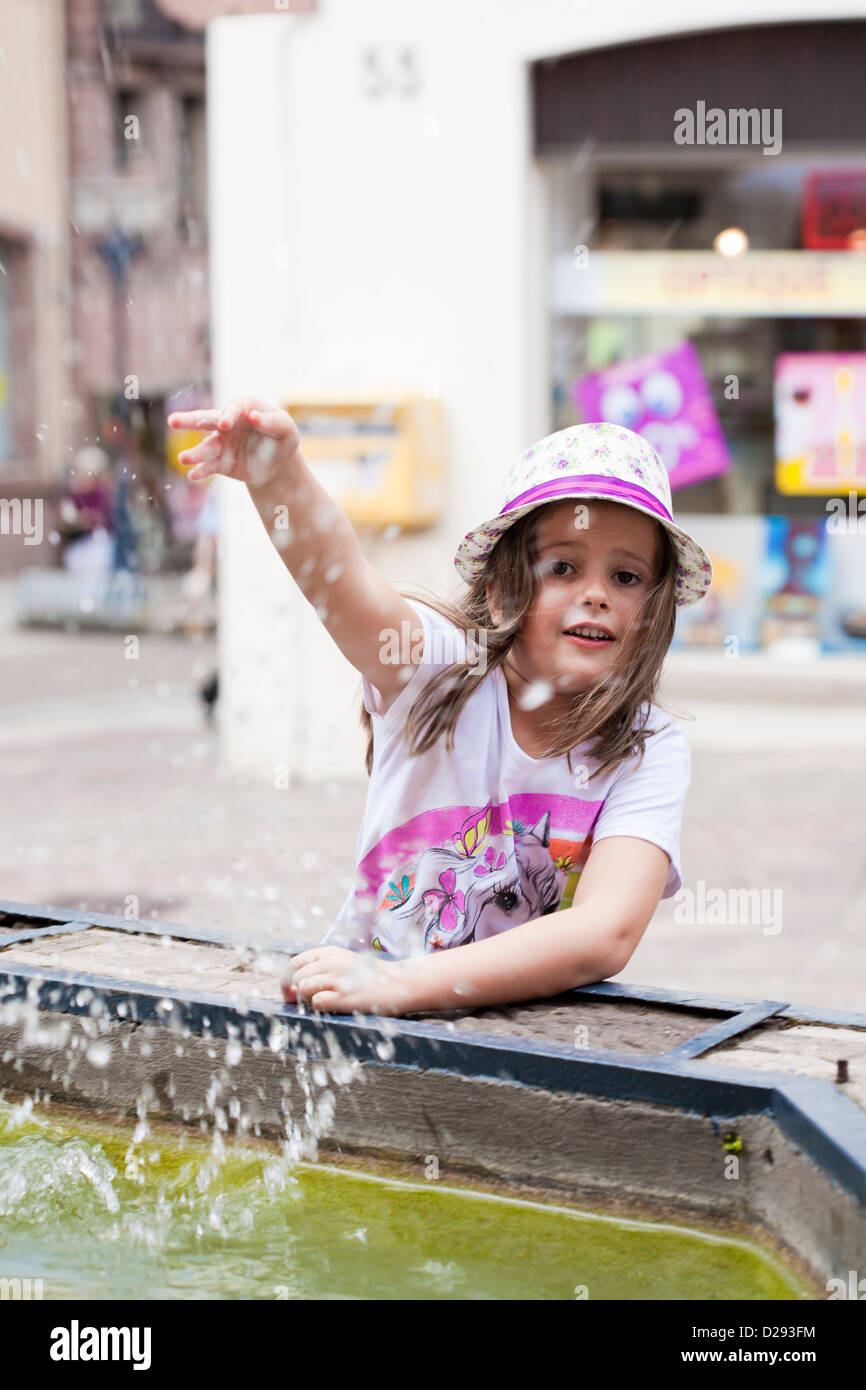 Girl playing with water of fountain Stock Photo - Alamy