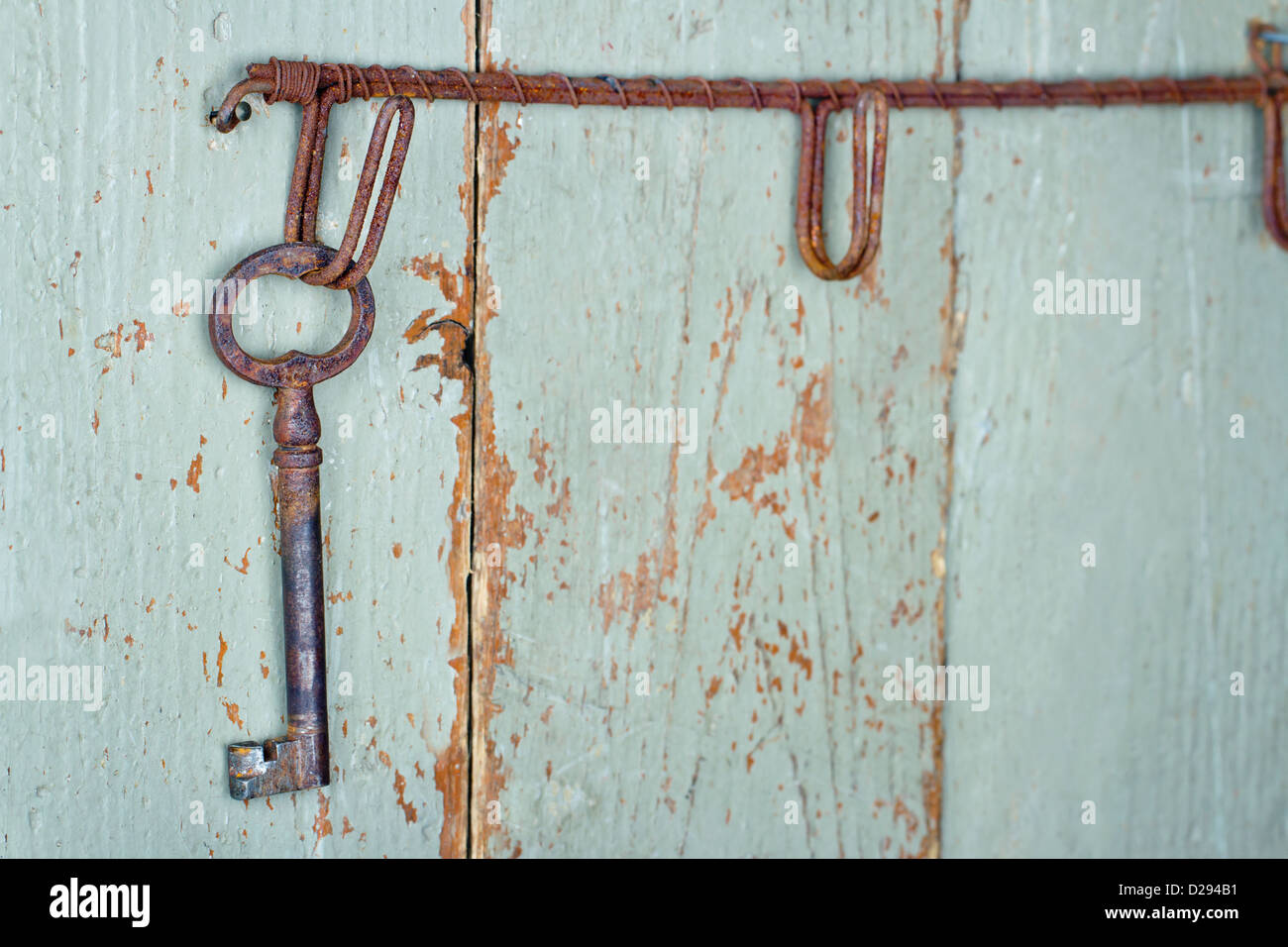 Old antique key hanging on wooden rustic green background Stock Photo