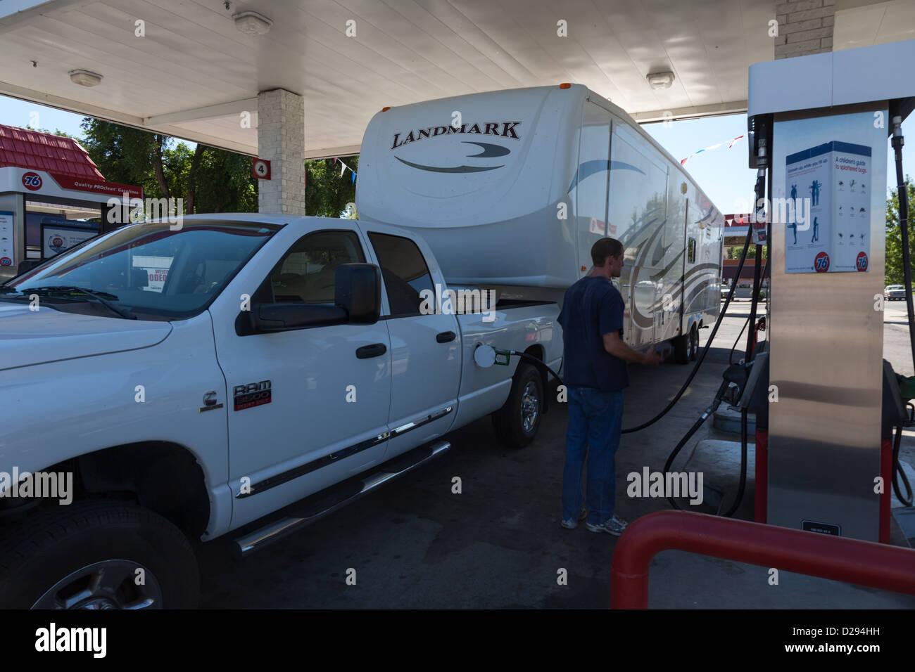 Large fifth wheel recreation vehicle with a white dodge one ton truck at gas filling station Stock Photo