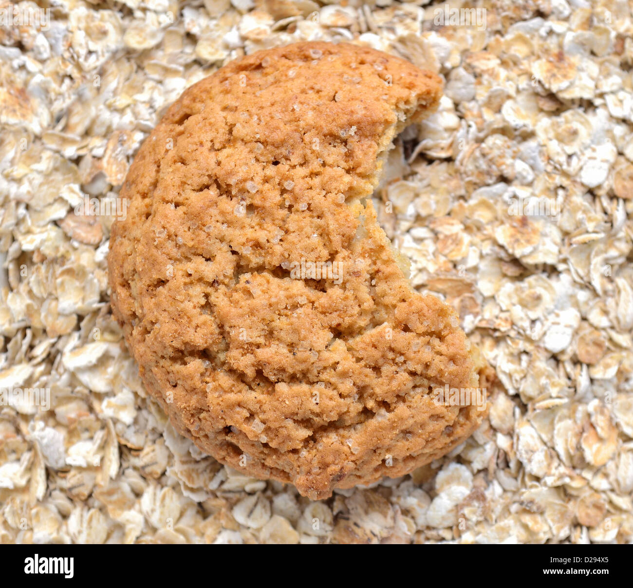 bitten oat cookie over oat flakes background Stock Photo