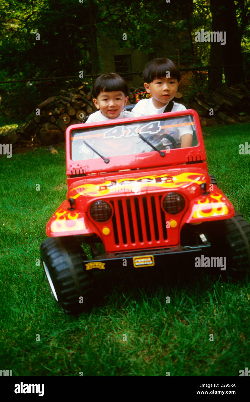 Chinese-American Boys (2 And 5 Years Old) Playing In Toy Jeep Stock Photo
