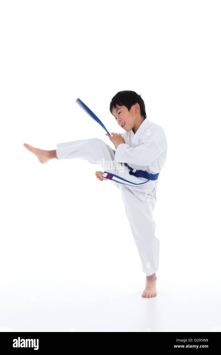 Young Asian boy with blue belt, Karate kicking in air Stock Photo