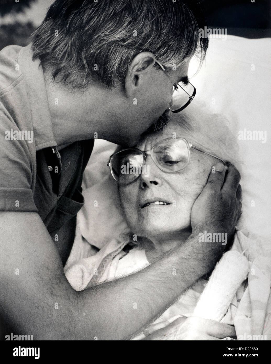 Mother With Alzheimer’S Disease, Being Kissed On Forehead By Son Stock Photo