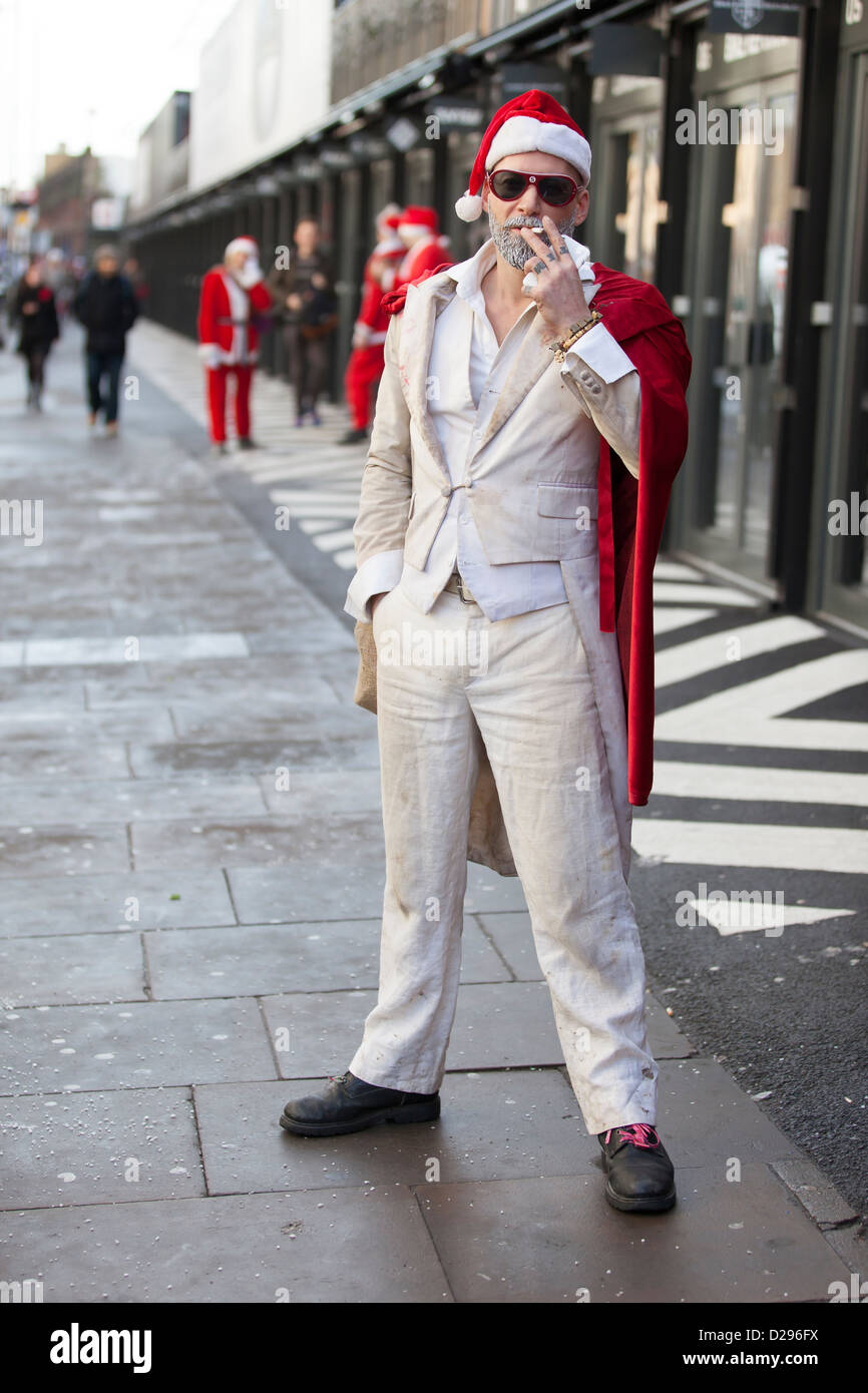 A reveller at Santacon, London, December 2012, pauses for a cigarette break. Stock Photo
