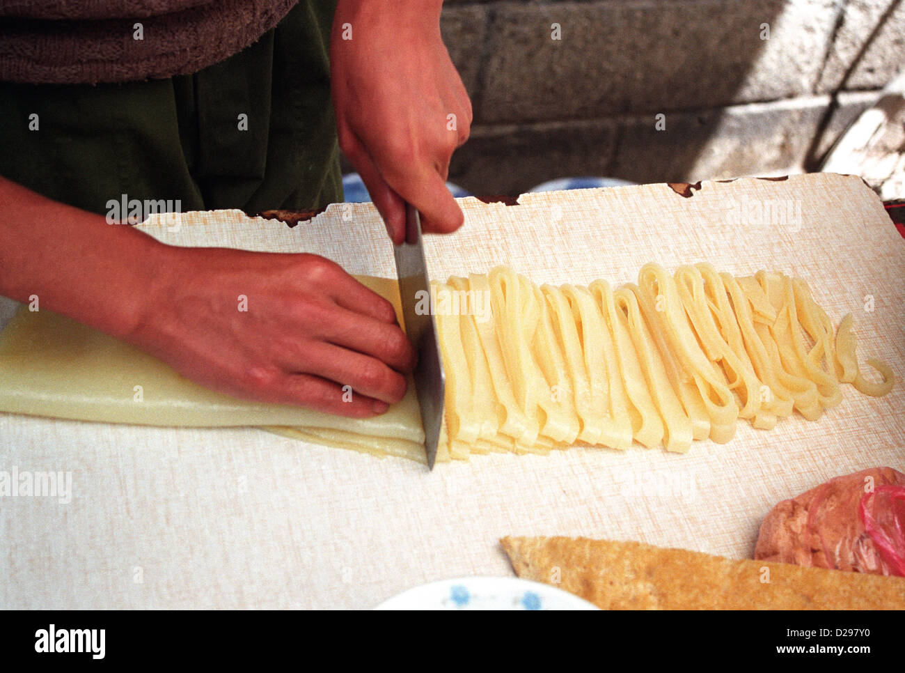 Tibet. Cutting Dough Into Noodles. Stock Photo