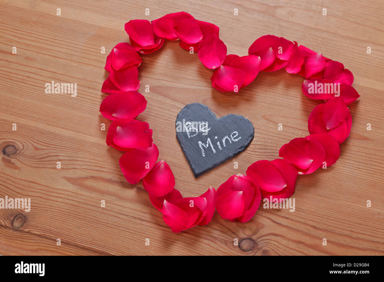 Red rose petals and slate in a heart shape with a romantic love ...
