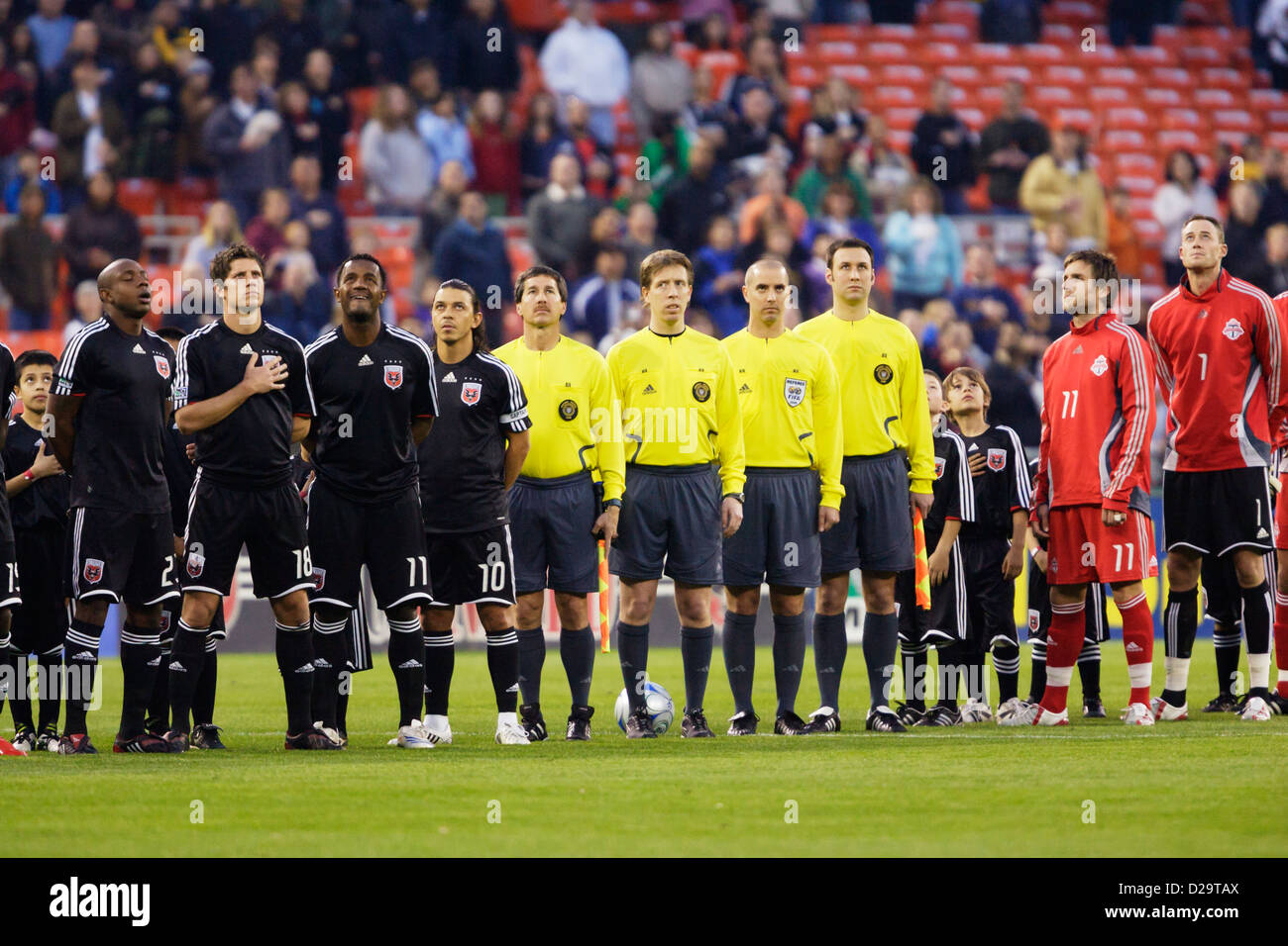The officiating team and players from DC United and Toronto line up for the national anthem before a Major League Soccer match. Stock Photo