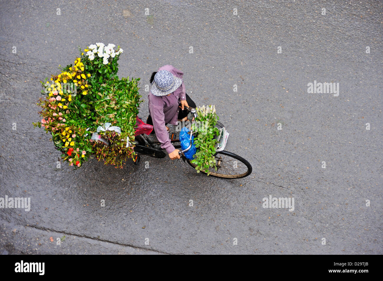 Hanoi, Vietnam - Vietnamese people, woman flower seller in the street Stock Photo