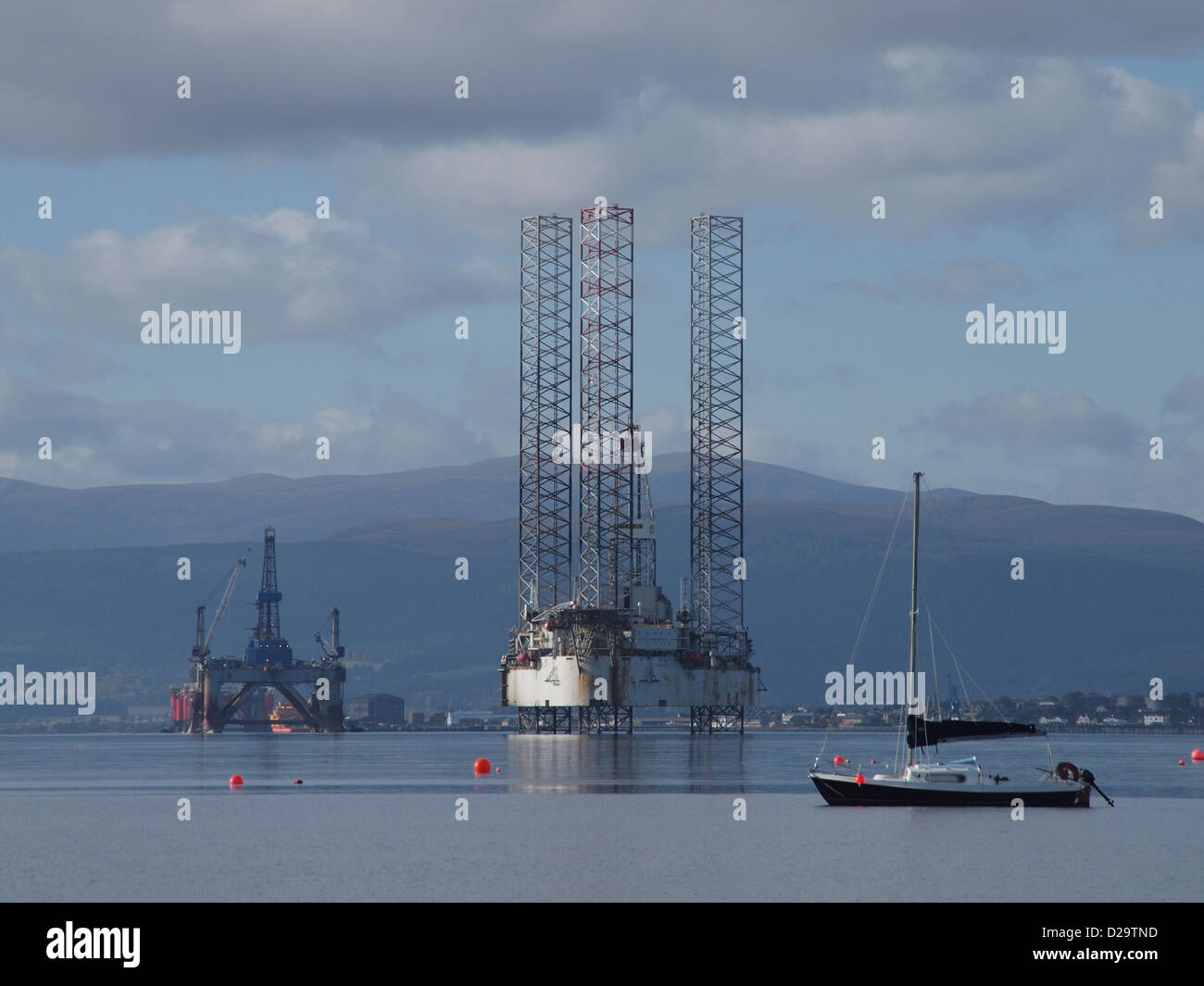 Oil rigs and a yacht  in the Cromarty Firth, Scotland Stock Photo