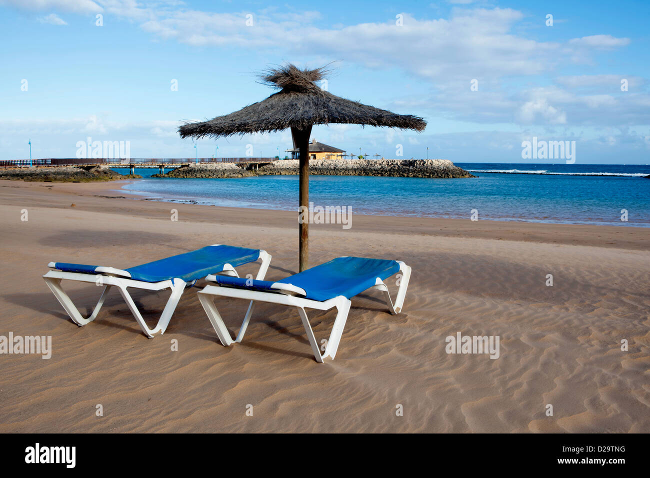 Relaxation. An image of lounger deck chairs with beach huts at the beach in Fuerteventura, Canary Islands, Spain. Stock Photo