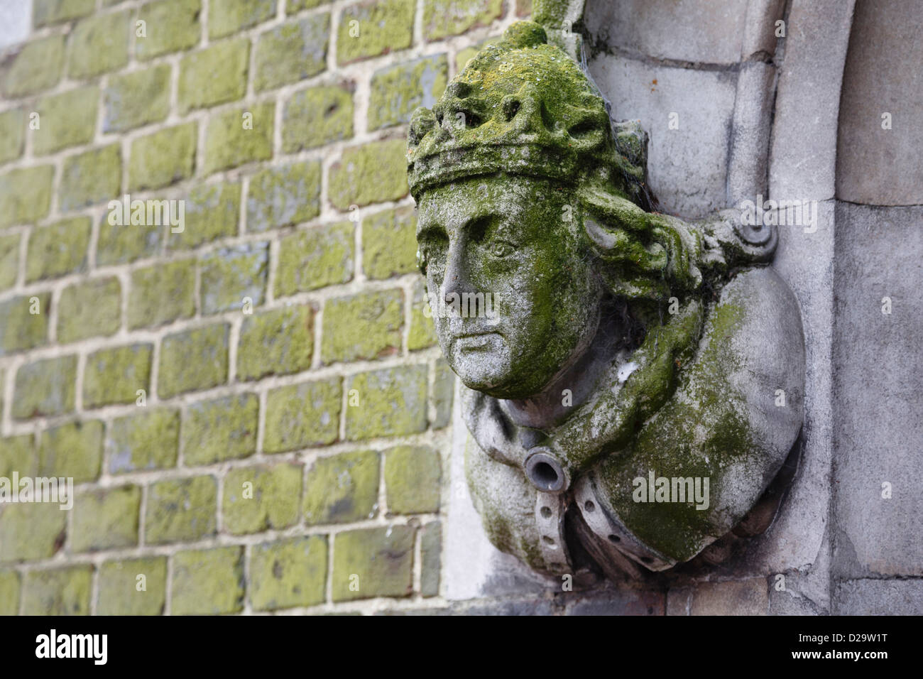 Detail of a historic building in Winchester with a carved stone figure head on the wall Stock Photo