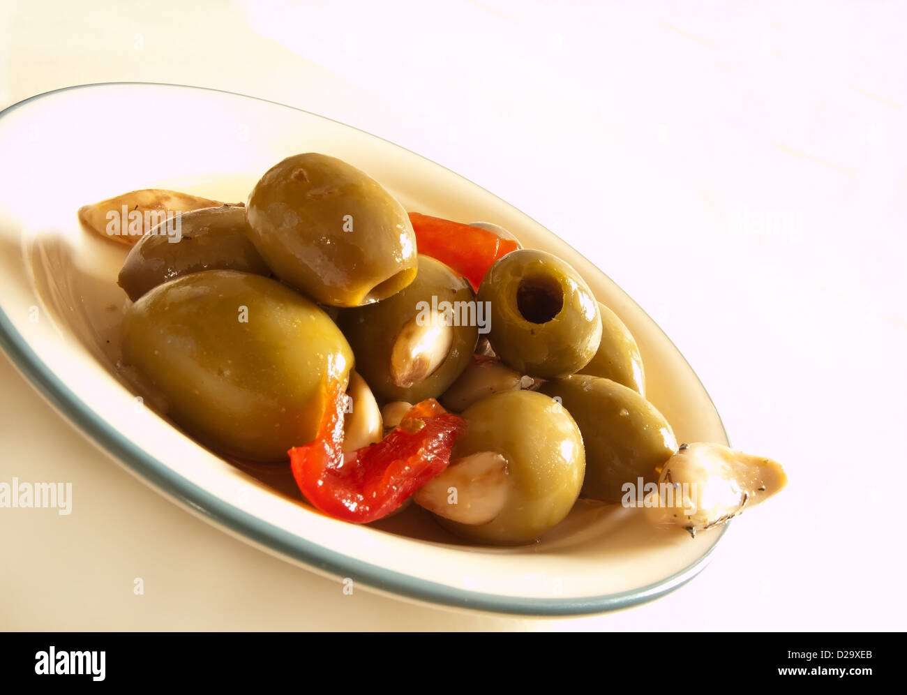 green olives stuffed with garlic cloves marinated in spices and olive oil Stock Photo