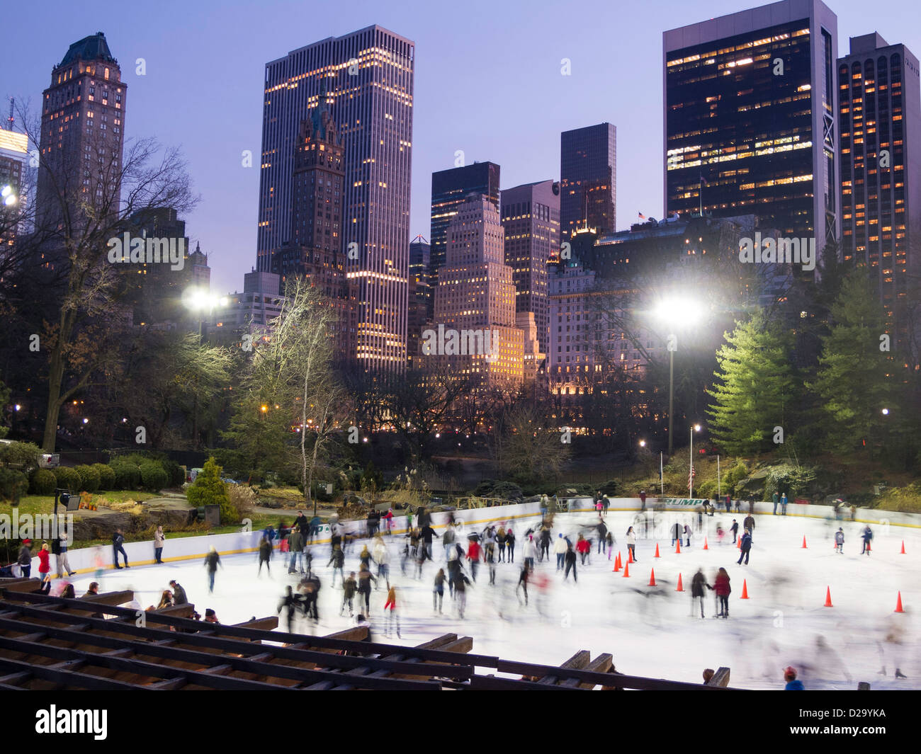 Wollman Rink Ice Skating in Central Park with Manhattan Skyline in background, NYC Stock Photo