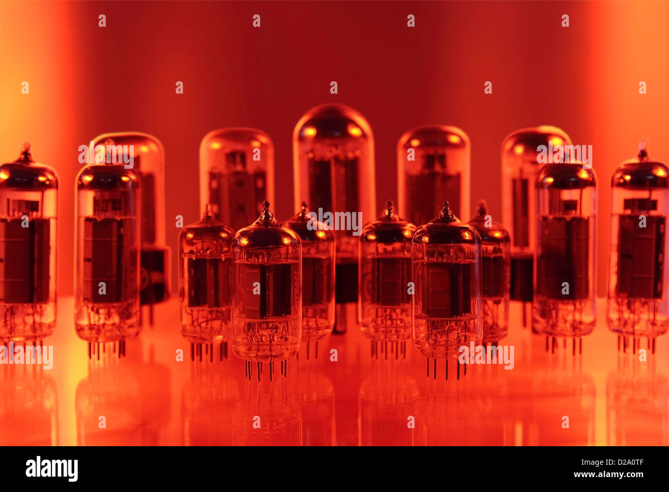 a set of electronic tubes or valves on a reflective surface. The