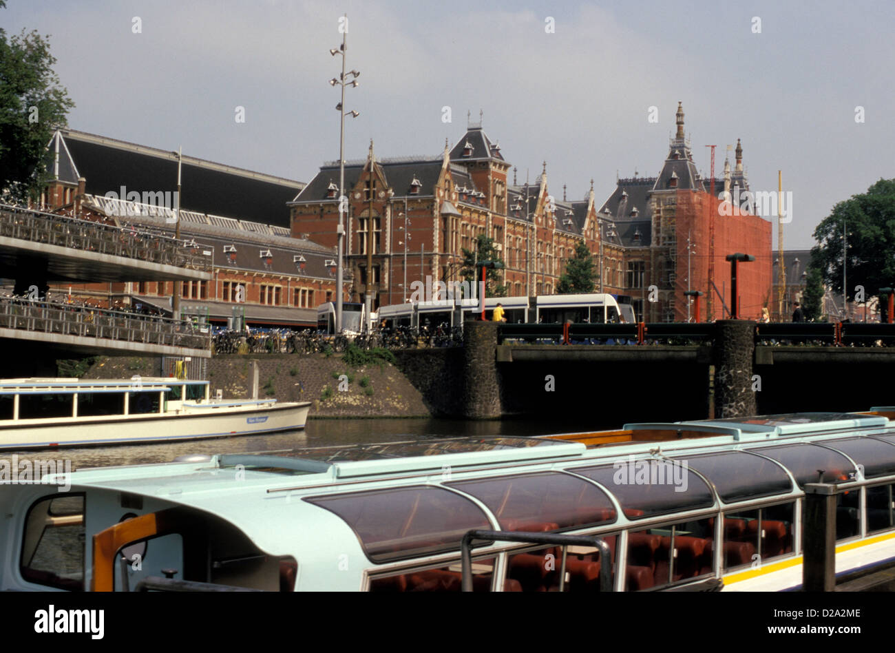 Netherlands. Amsterdam. Centraal Station. Canal. Tour Boats. Bicycle Parking. Stock Photo