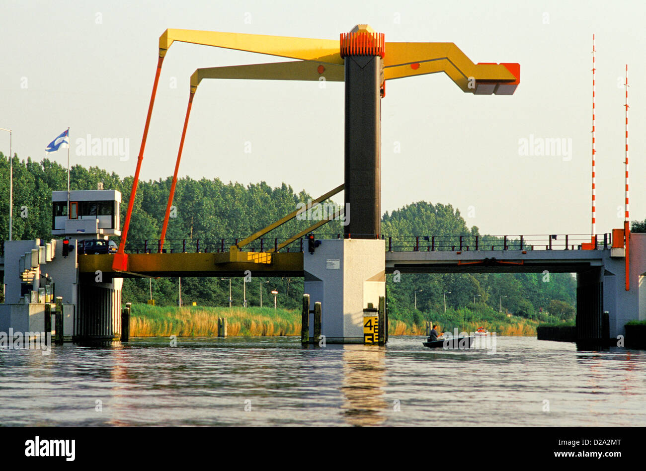 Netherlands. Near Amsterdam. Bridge With Small Boat Crossing Under. Canal. Stock Photo