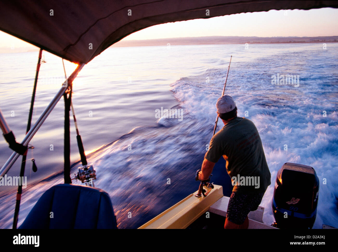 Man Rigging Deep Sea Fishing Poles On Fishing Boat Off The North