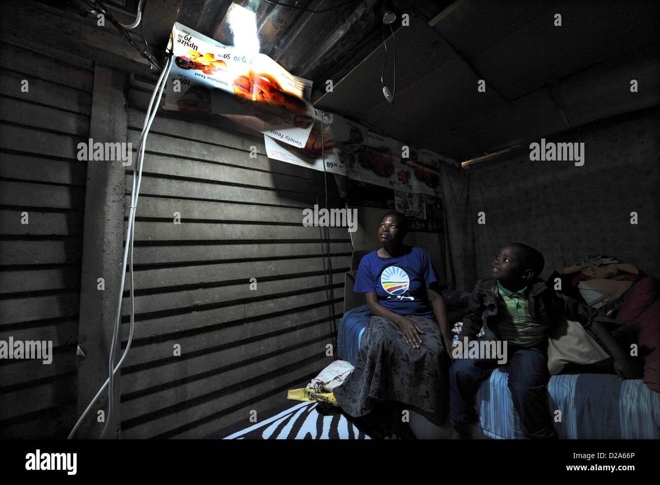 Johannesburg, South Africa. 18th January 2013.  Mavis Mabaso and her son Sphsihle showing their new bottle light on January 18, 2013, in Johannesburg, South Africa. The "Lïtre of Light" project puts plastic bottles filled with water in shack roofs, providing light to shacks with no electricity during the day. Credit:  Gallo images / Alamy Live News Stock Photo