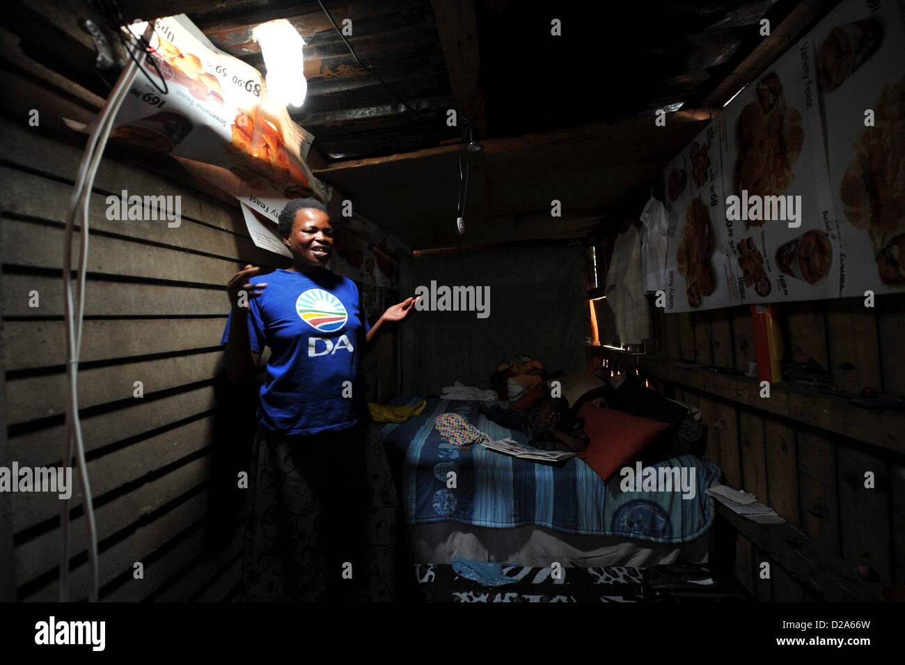 Johannesburg, South Africa. 18th January 2013.  Mavis Mabaso and her son Sphsihle showing their new bottle light on January 18, 2013, in Johannesburg, South Africa. The 'Lïtre of Light' project puts plastic bottles filled with water in shack roofs, providing light to shacks with no electricity during the day. Credit:  Gallo images / Alamy Live News Stock Photo