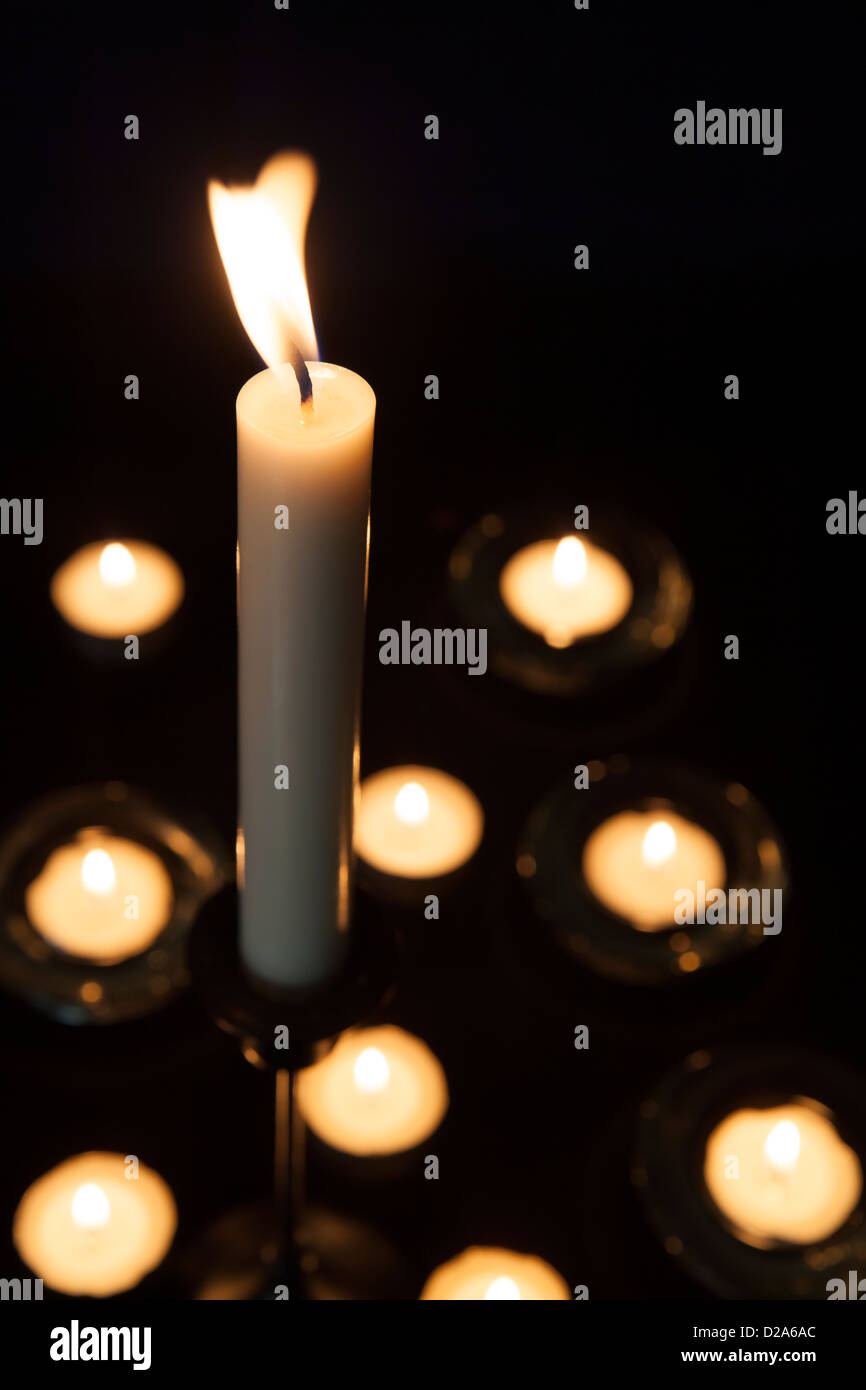 Lit candle and tea lights in holders Stock Photo Alamy