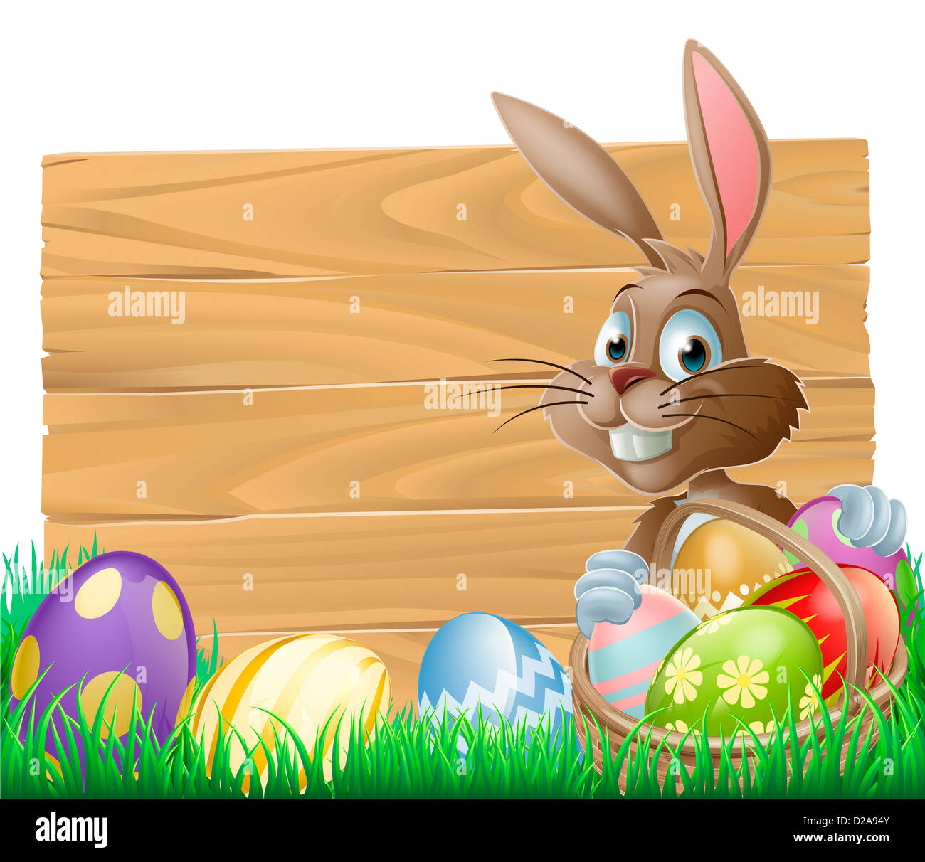 The Easter bunny with a basket of Easter eggs with more Easter eggs around him by a wood sign board Stock Photo