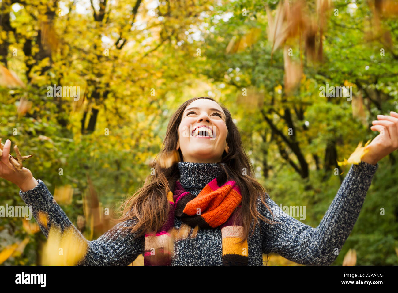 Woman playing in autumn leaves Stock Photo