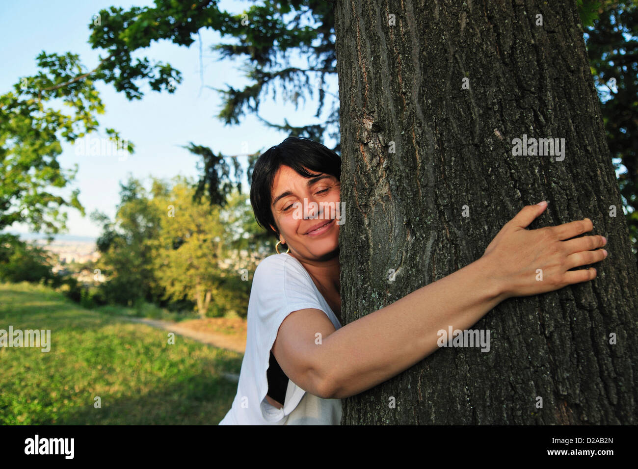 Woman hugging tree in forest Stock Photo