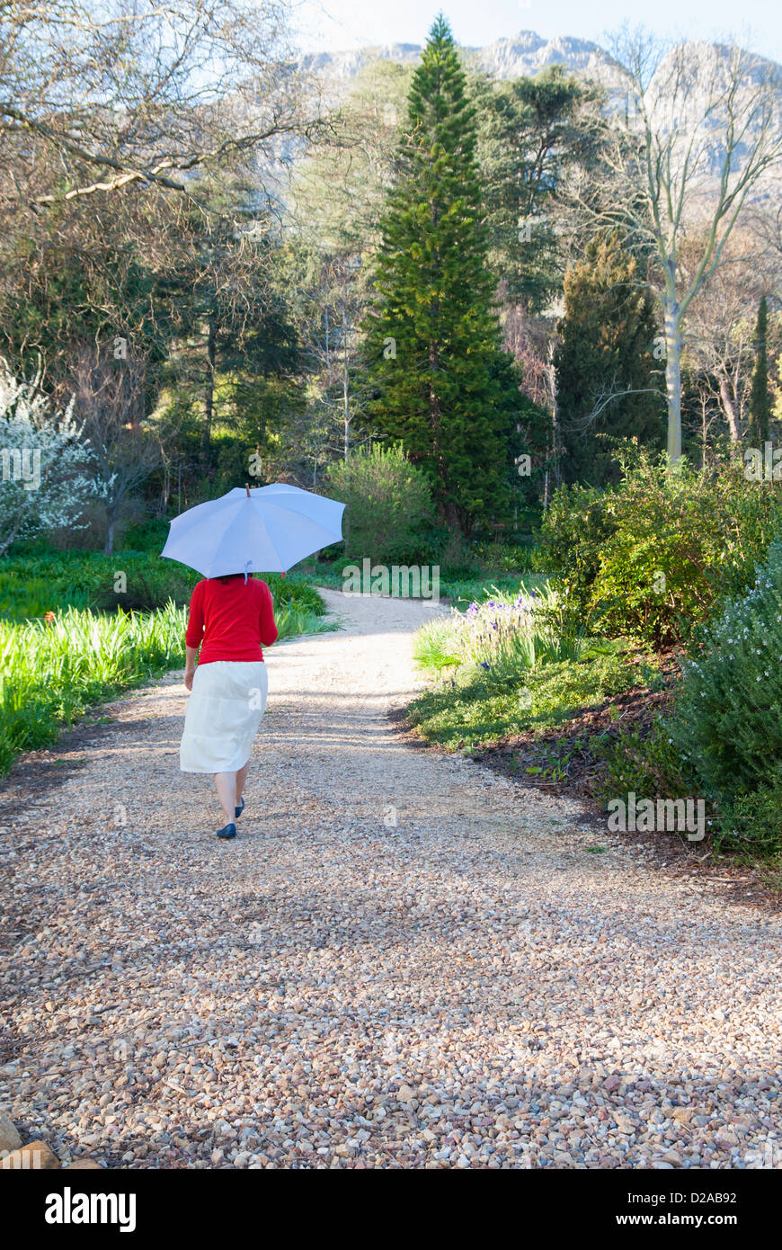 Woman carrying umbrella outdoors Stock Photo