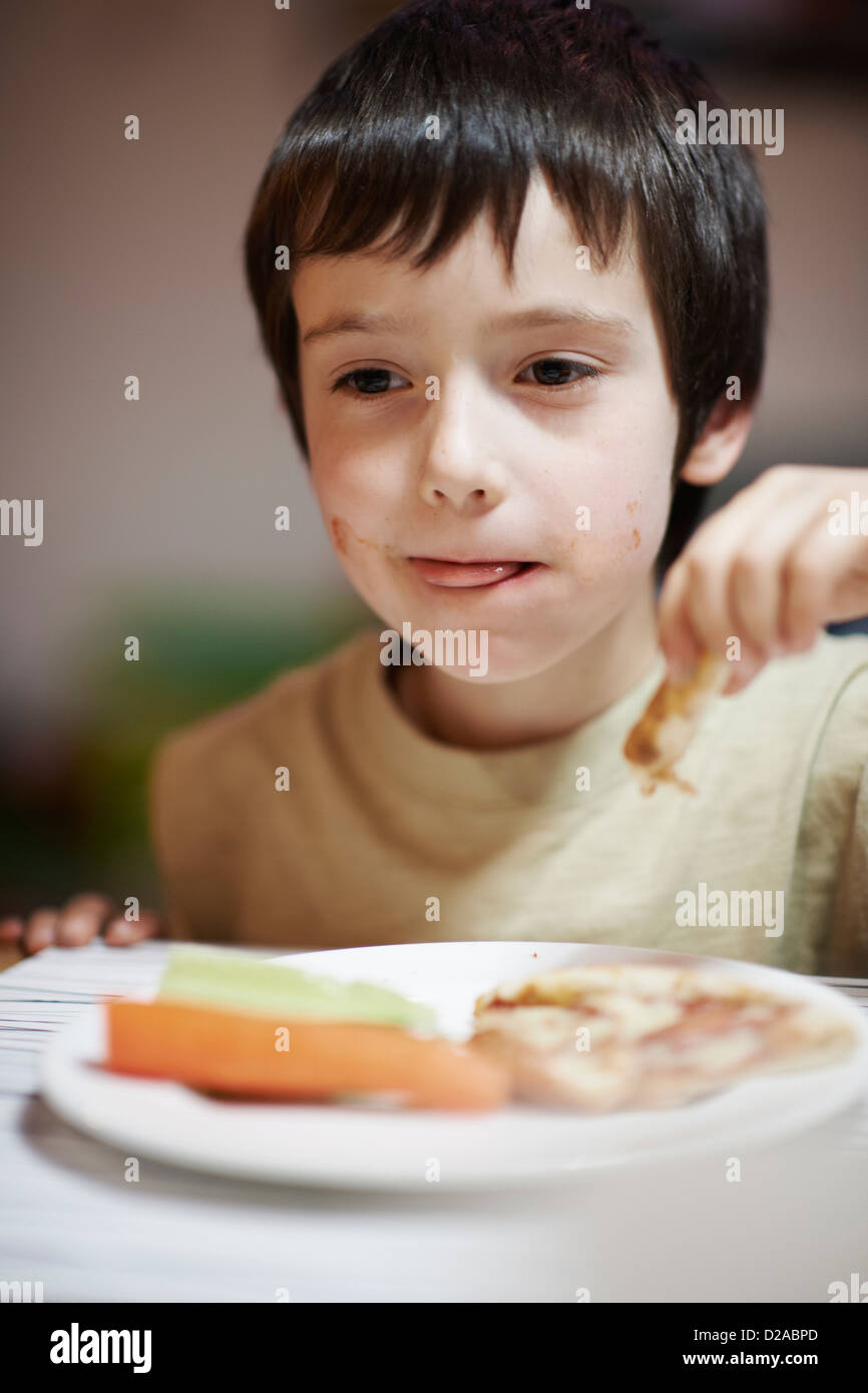 Boy eating at table Stock Photo