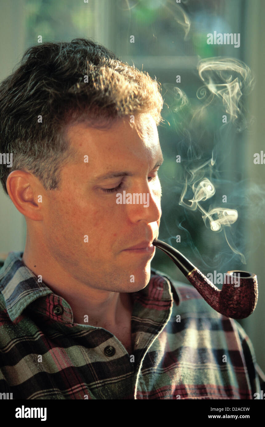 Portrait Of Man Smoking A Pipe At Home Stock Photo