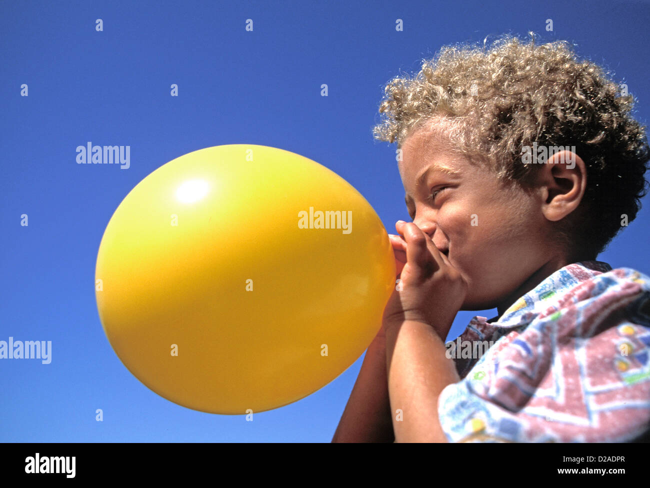 Boy Blowing Up Balloon Stock Photo Alamy