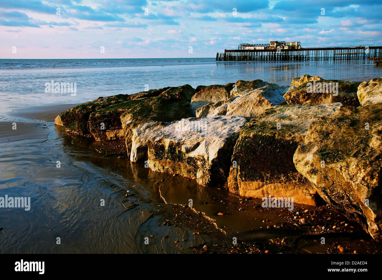 hastings seafront in january at sunrise showing the pier and beach rocks Stock Photo