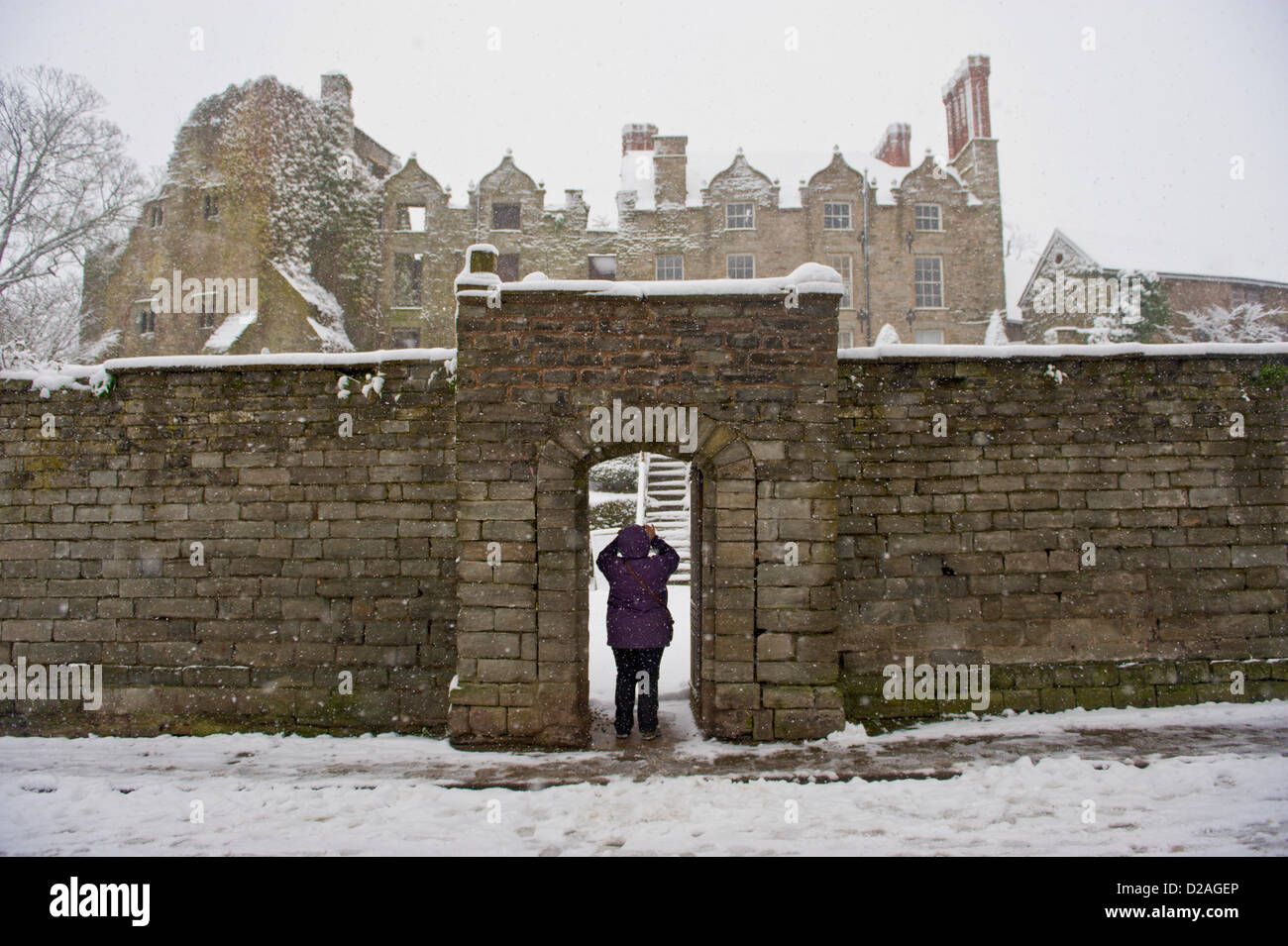 Woman taking photograph of Jacobean Hay Castle covered in snow. Hay-on-Wye Powys Wales UK. 18th January 2013. Credit: Jeff Morgan/Alamy Live News Stock Photo
