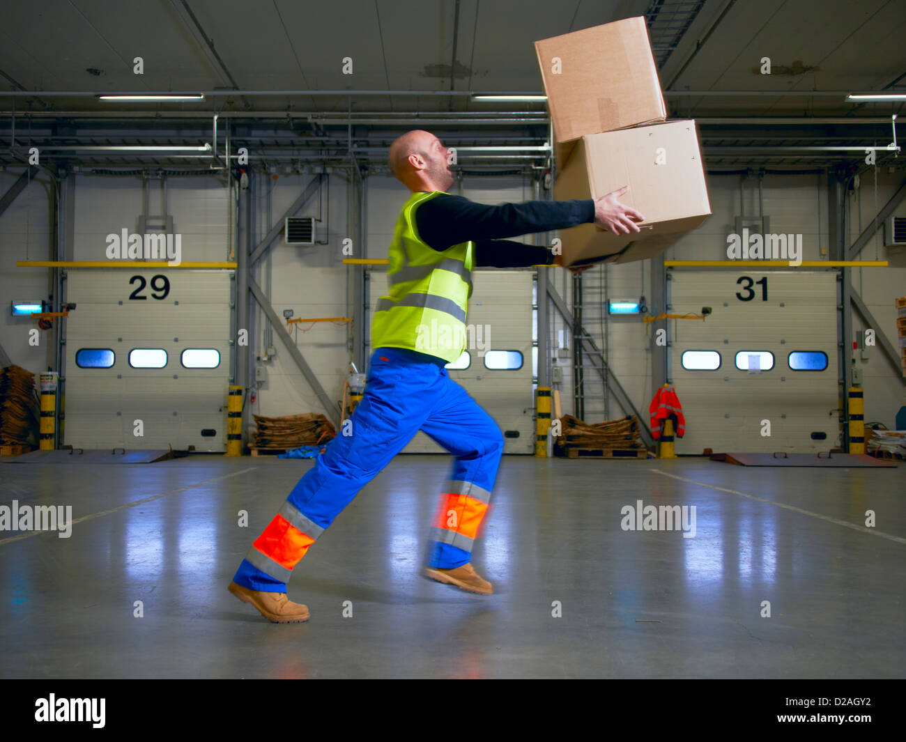 Worker balancing boxes in warehouse Stock Photo