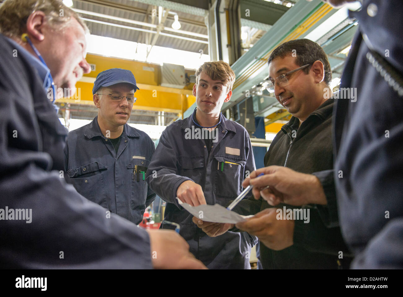 Apprentices talking in factory Stock Photo