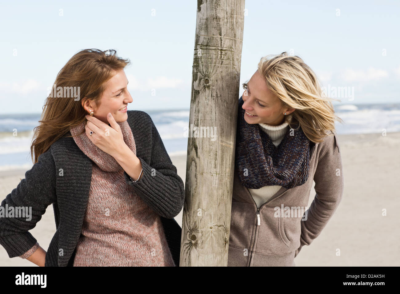 Smiling women talking on beach Stock Photo
