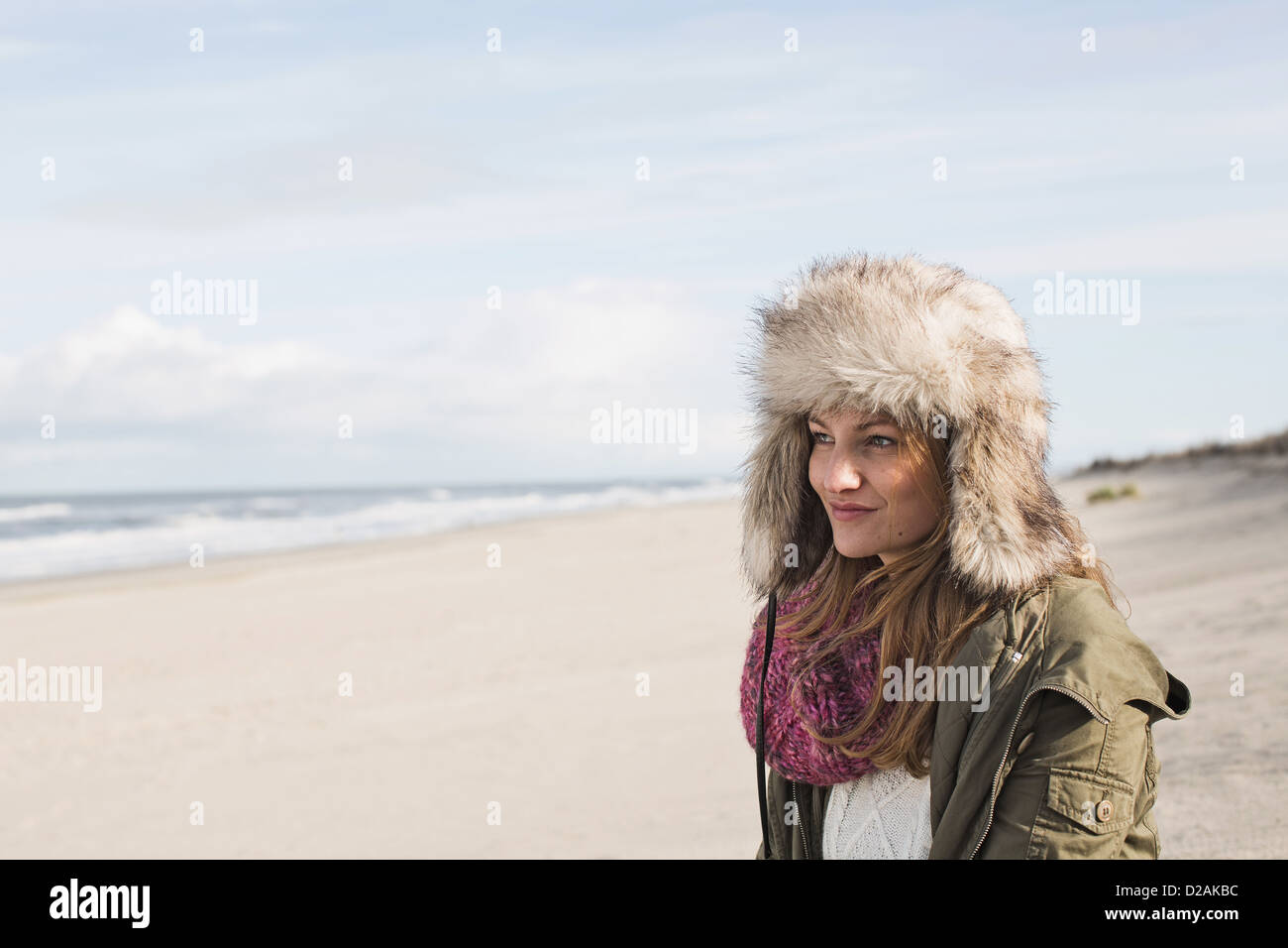Smiling woman standing on beach Stock Photo