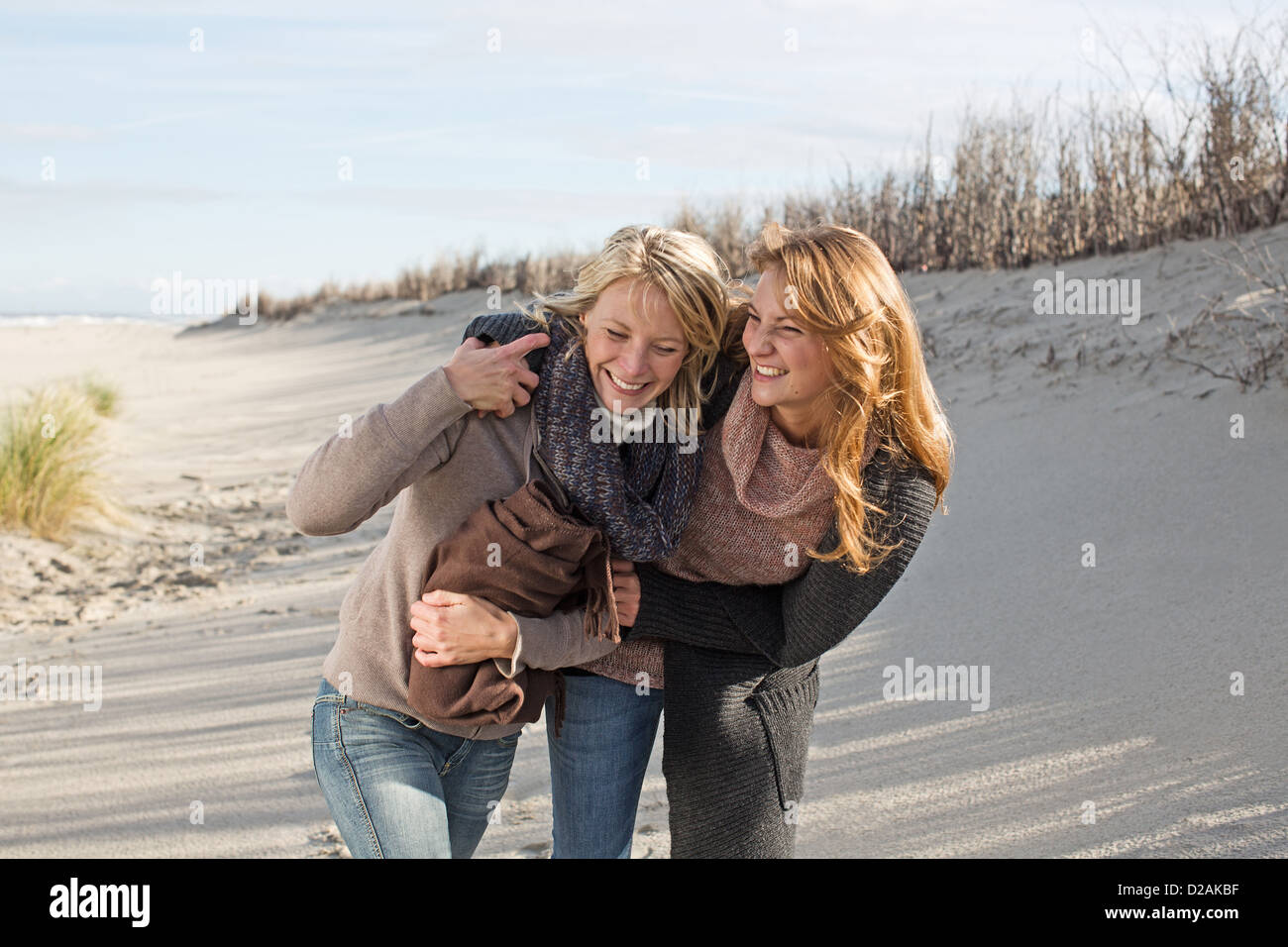 Smiling women walking on beach Stock Photo - Alamy