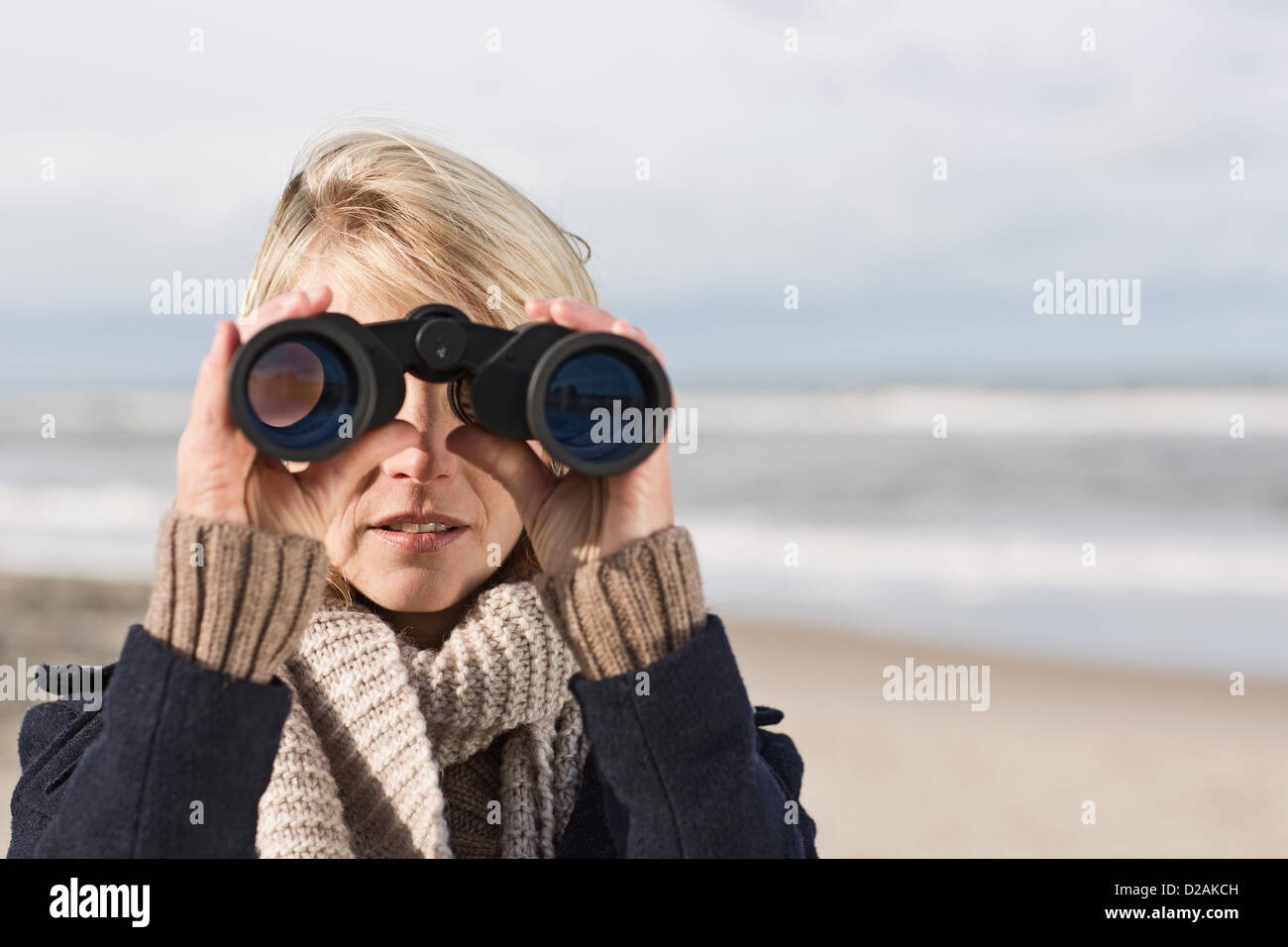 Woman using binoculars on beach Stock Photo Alamy