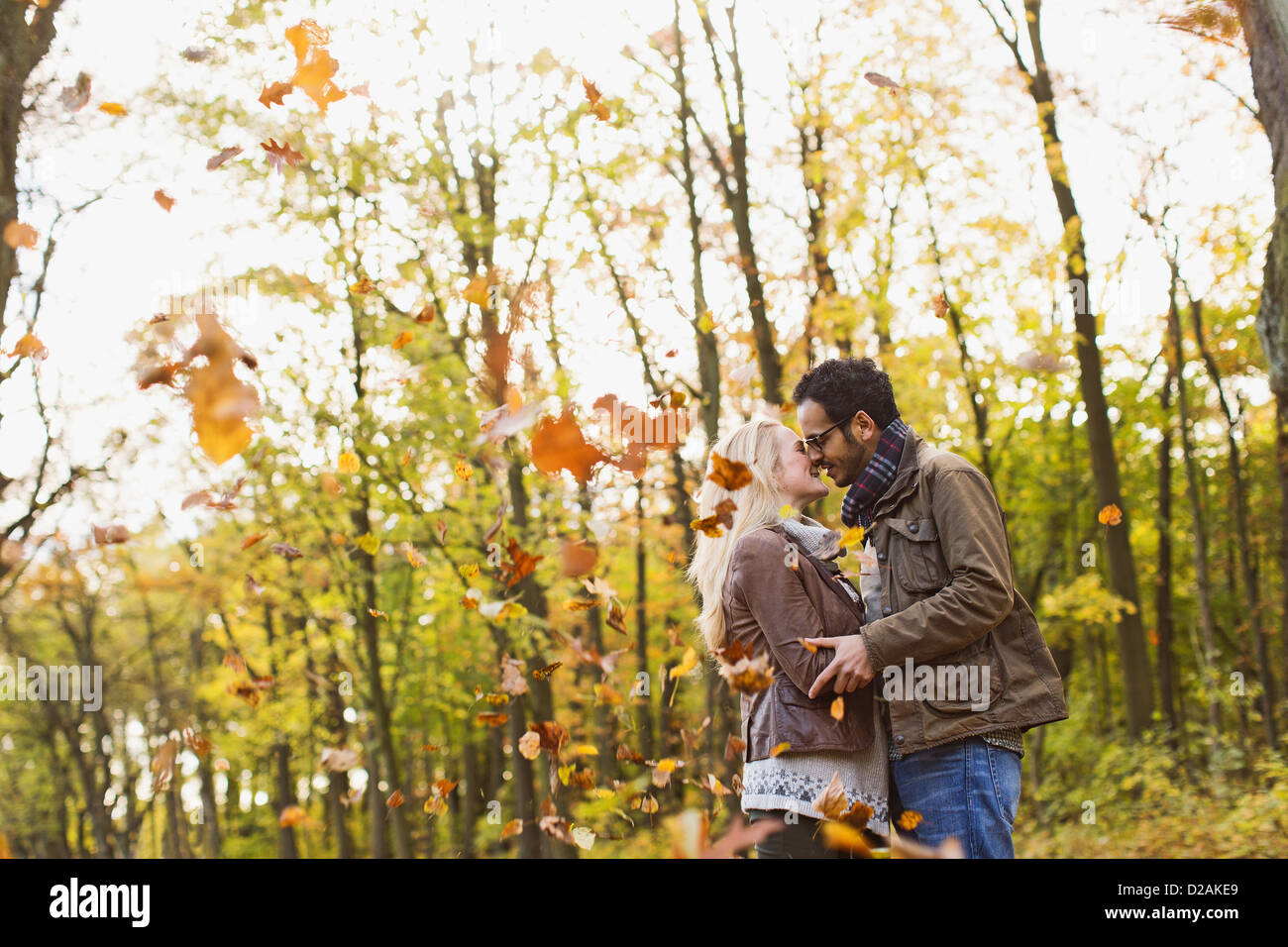 Smiling couple kissing in forest Stock Photo