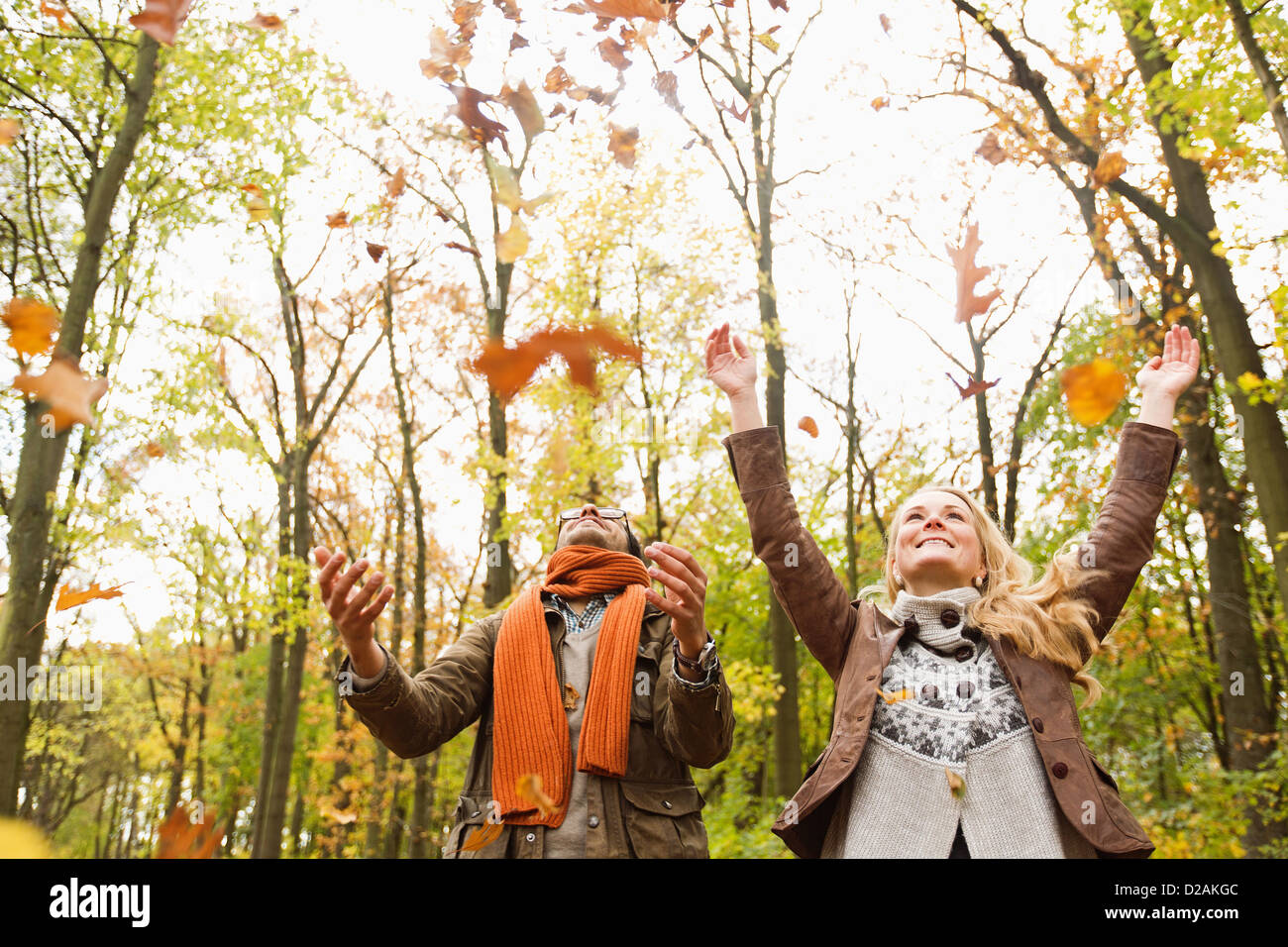 Smiling couple playing in autumn leaves Stock Photo