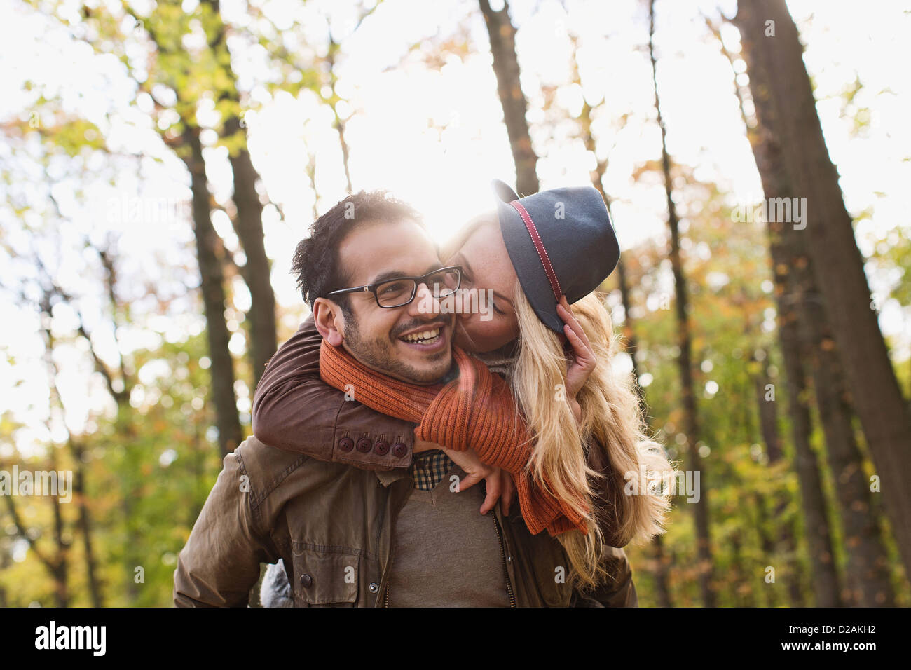 Smiling couple kissing in forest Stock Photo