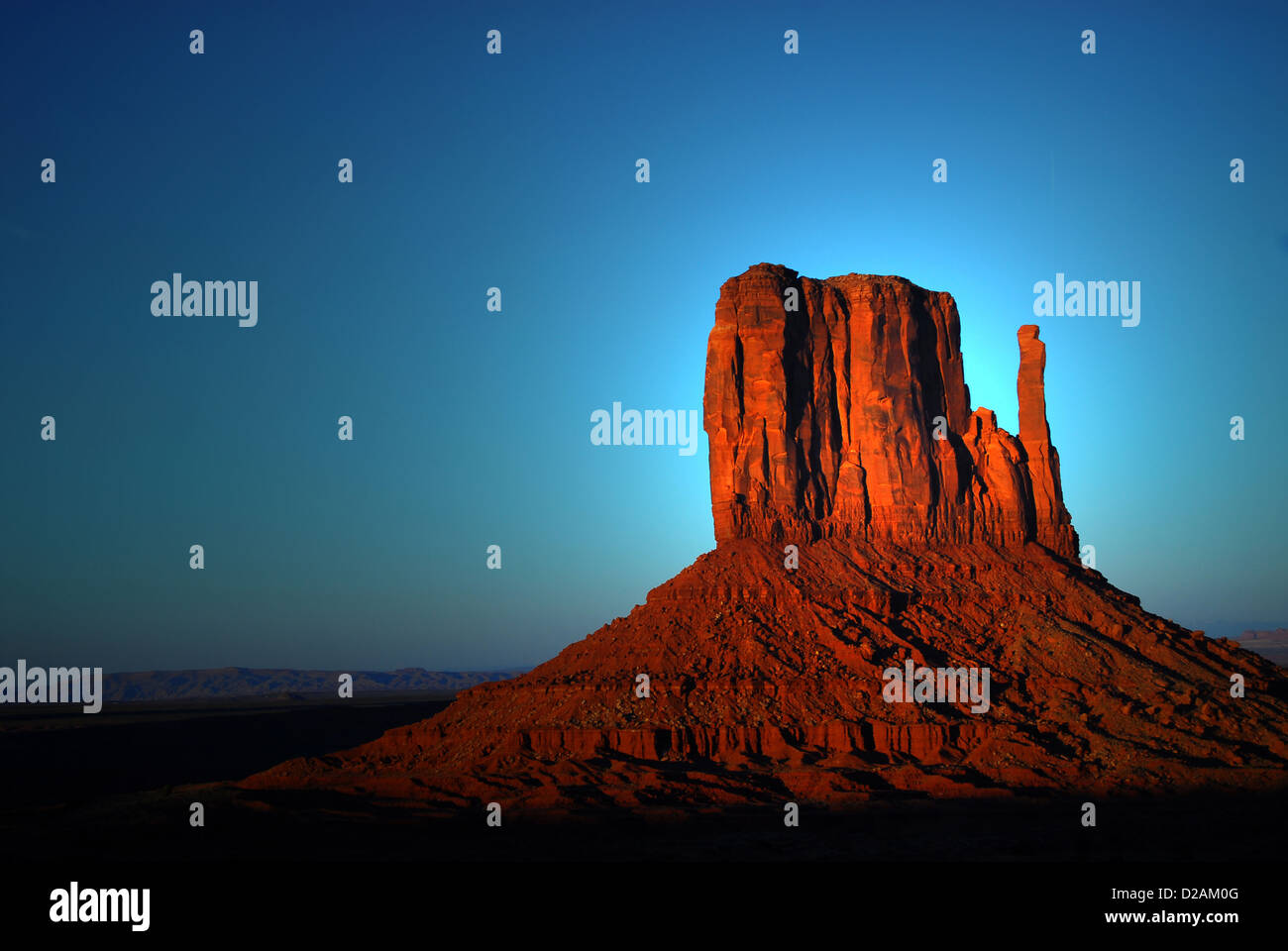 Dramatic light of dawn striking a rock formation in the Navajo nation land of Monument Valley Stock Photo