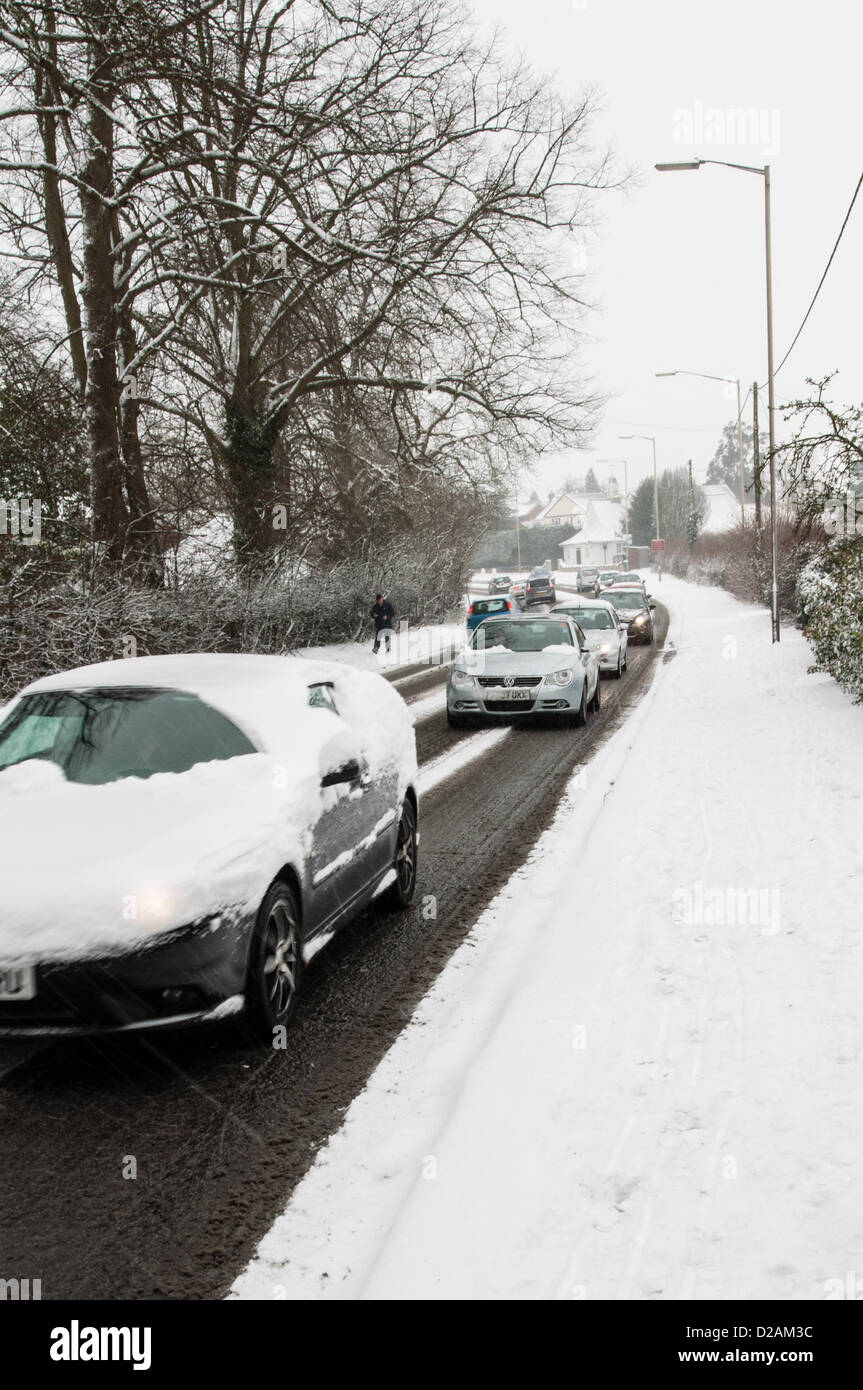 18th January 2013, Buckinghamshire, UK.  Traffic moves slowly through a Buckinghamshire village during heavy snowfall. Stock Photo