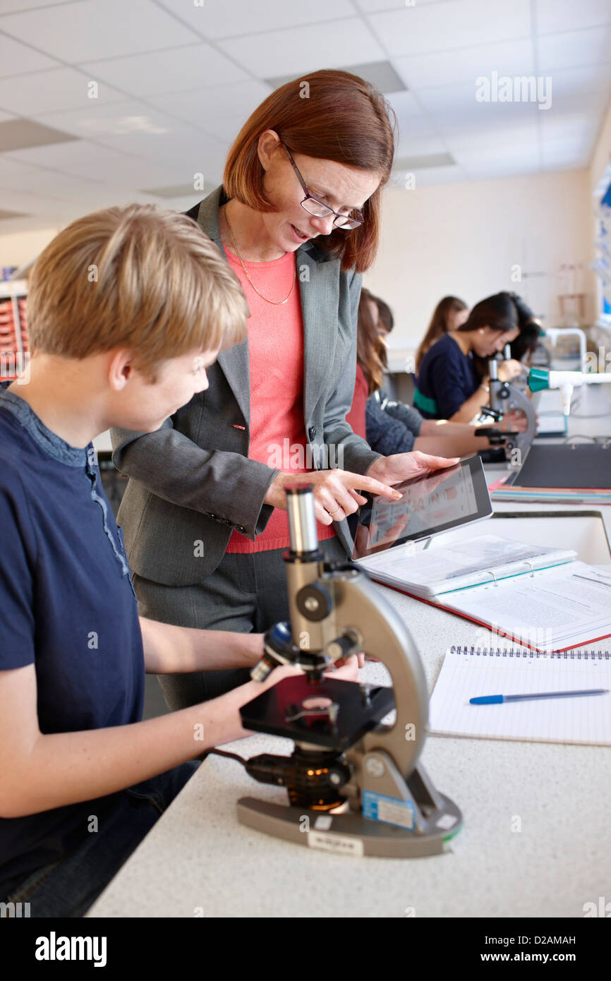 Teacher with student in science class Stock Photo
