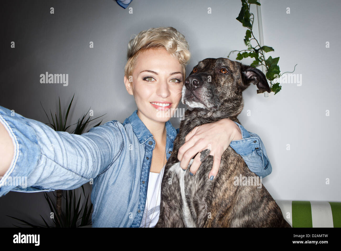 Smiling woman taking picture with dog Stock Photo